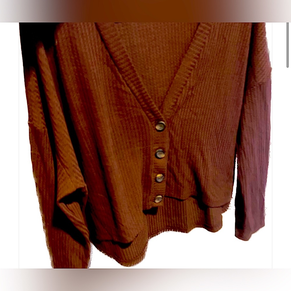 Burgundy button cropped long sleeve. Flowing style with a high cut in the front